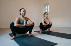Young adult women practicing yoga in garland position